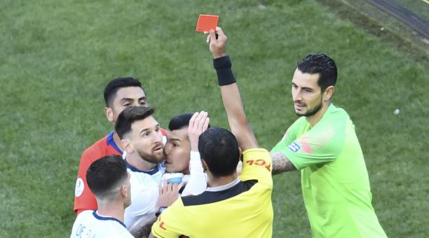 El árbitro Mario Díaz de Vivar le muestra la tarjeta roja al argentino Lionel Messi. Foto: AFP