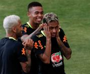 Neymar (der.), Gabriel Jesús (centro) y Dani Alves bromean antes de la práctica de Brasil. Foto: AFP