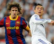 Carles Puyol (izq.) disputa el balón con Cristiano Ronaldo en un clásico español